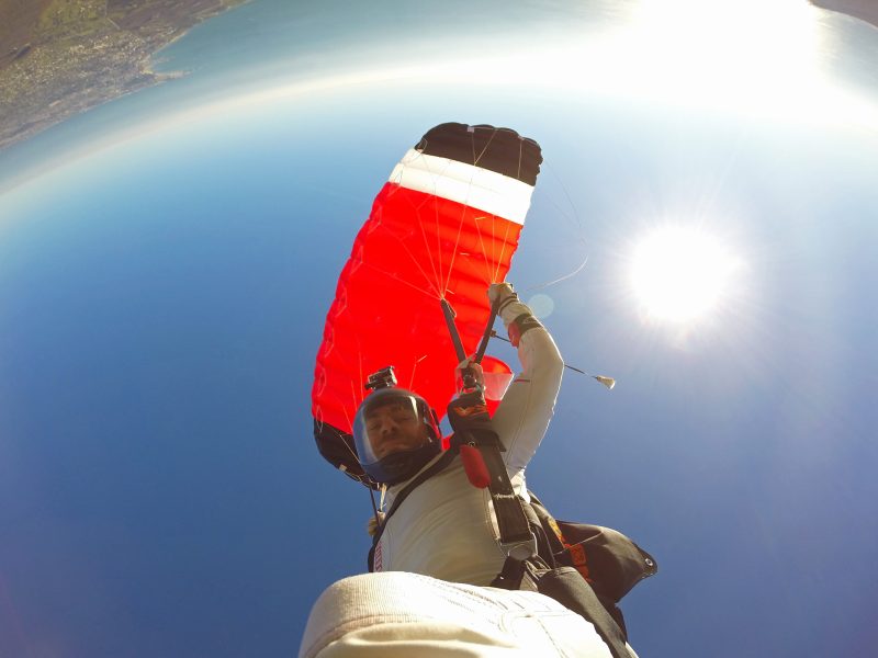 Skydiver pulling front risers of an XFire parachute